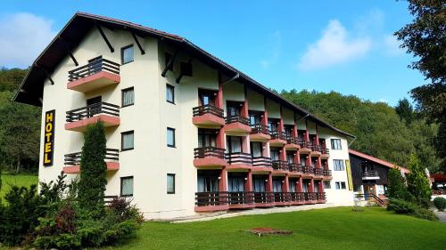 a large building with balconies on the side of it at Hotel Mladost in Tjentište