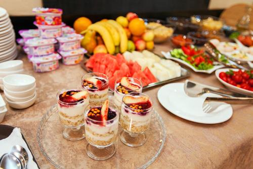 a table with four glasses of desserts and fruit at Lumarc Hotel in Bishkek