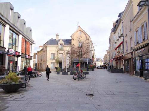 a city street with people walking down the street at Les Clochers d'Or in Chartres