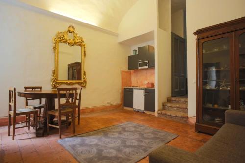 - un salon avec une table et un miroir dans l'établissement Two rooms apartment in Palazzo Malaspina, à Plaisance