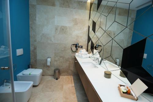 a bathroom with a sink and a toilet and a mirror at Valentino Rooms in Focşani