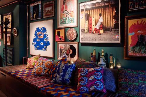 a living room with a couch and pictures on the wall at 25hours Hotel Terminus Nord in Paris
