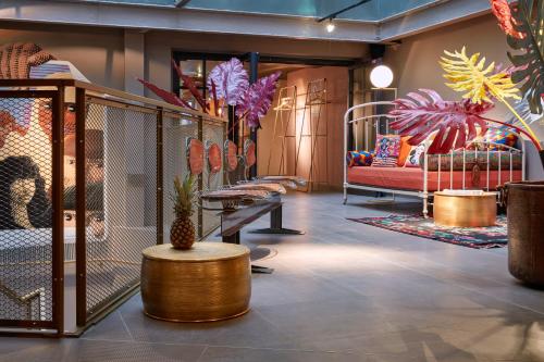 a room with a couch and a table and plants at 25hours Hotel Terminus Nord in Paris