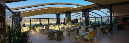a restaurant with tables and chairs in a building at Golden Tulip Al Khobar Suites in Al Khobar