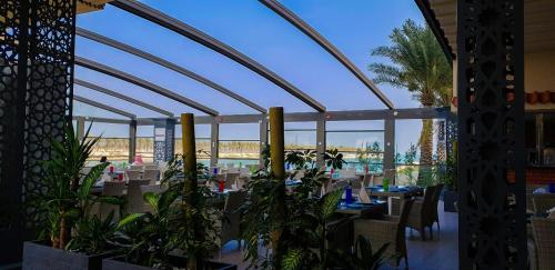 a restaurant with tables and plants in a building at Golden Tulip Al Khobar Suites in Al Khobar