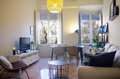 een woonkamer met een bank en een tafel bij Apartament en Plaça Nova , Palafrugell in Palafrugell