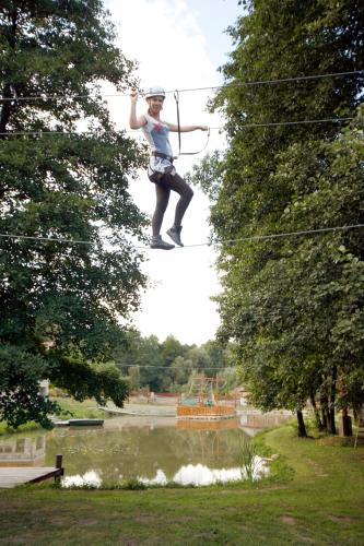 a person on a zip line over a river at Aranybánya Panzió és Apartmanház in Telkibánya