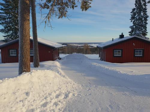a snow covered road next to a red building at First Camp Frösön-Östersund in Frösö