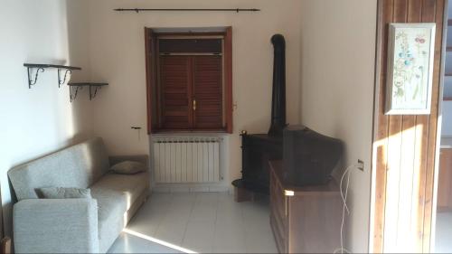a living room with a couch and a stove at La Magnolia sul Lago in Campolattaro
