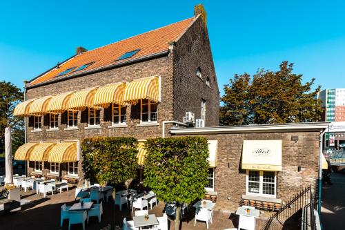 a building with tables and chairs in front of it at De Pastorie Bed & Breakfast in Roermond