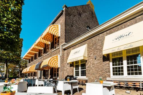 a brick building with tables and chairs in front of it at De Pastorie Bed & Breakfast in Roermond