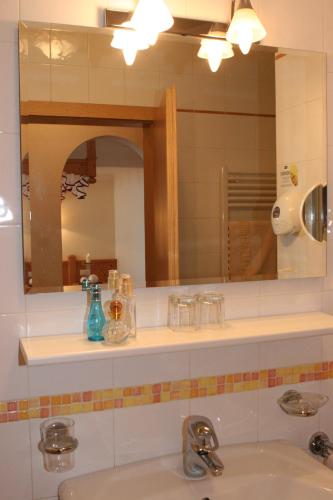 a bathroom with two sinks and a mirror at Hotel Amaten in Brunico