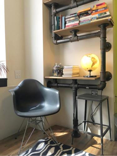 a black desk with a chair and a globe on a shelf at American Dream in New York