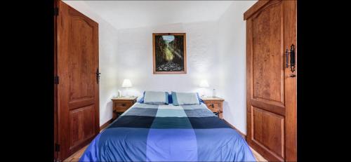 1 dormitorio con cama azul y almohadas azules en Casa Cora Con Jacuzzi, en Breña Baja