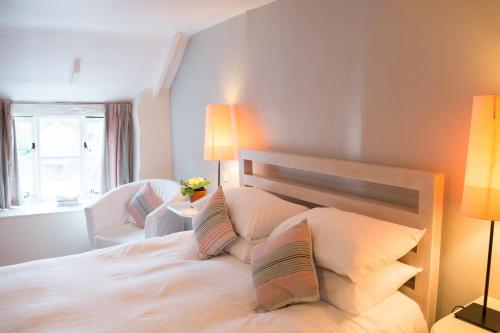 a bedroom with a large white bed with two lamps at The Rose & Crown, Snettisham in Snettisham