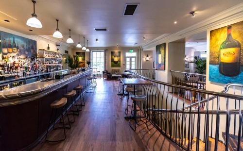 a bar in a restaurant with bar stools at Hotel du Vin & Bistro Harrogate in Harrogate