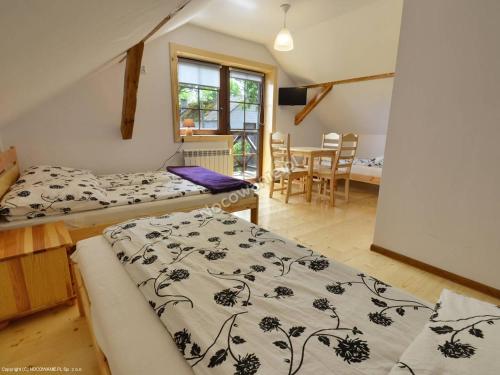 a bedroom with two beds and a table with chairs at Dom Wypoczynkowy przy Szlaku OJCÓW in Ojców