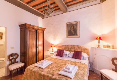 a bedroom with a bed with two towels on it at Castello di San Fabiano in Monteroni dʼArbia