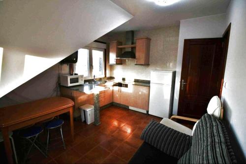 a small kitchen with a counter and a table in it at Piso Don Ramón in Razo
