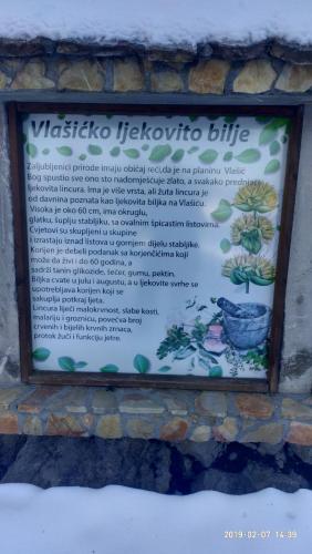 a sign on a stone wall with a plant at Apartman Hasen Vlašić in Vlasic