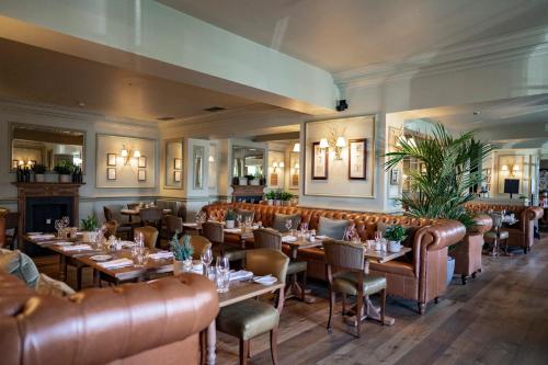 um restaurante com mesas e cadeiras e uma lareira em Hotel du Vin & Bistro Harrogate em Harrogate