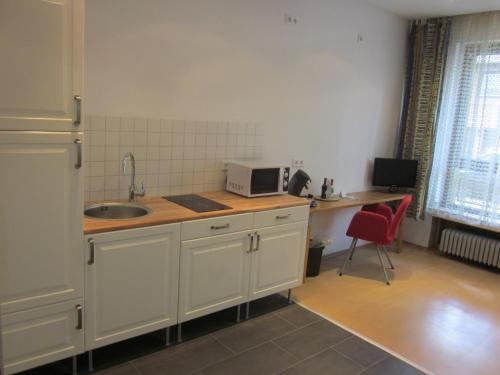 a kitchen with a sink and a counter with a microwave at Hotel Waldesruh in Düsseldorf