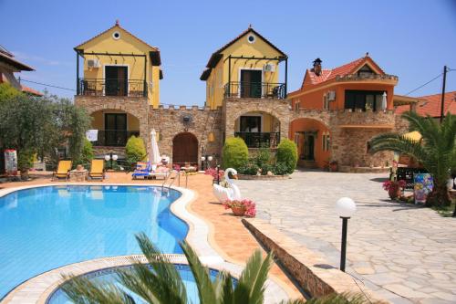 a large house with a swimming pool in front of it at Kastro in Skala Potamias