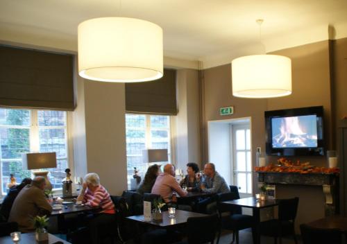 ルールモントにあるDe Pastorie Bed & Breakfastのレストランのテーブルに座っている人々のグループ