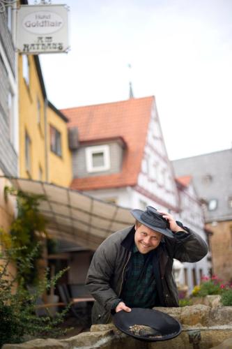 a man is holding a frisbee on the street at Hotel Goldflair am Rathaus in Korbach