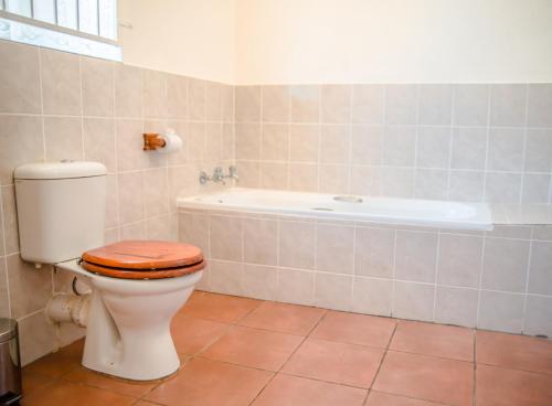 a bathroom with a toilet and a bath tub at Loskop Valley Lodge in Groblersdal