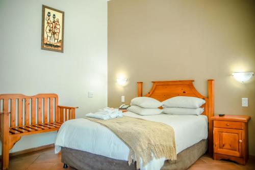 a bedroom with a large bed and a crib at Loskop Valley Lodge in Groblersdal