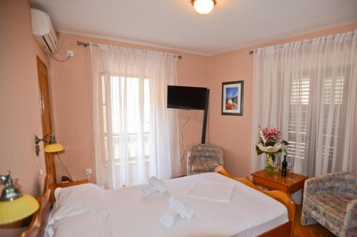 - une chambre avec un lit et une télévision dans l'établissement Hotel Marija, à Kotor