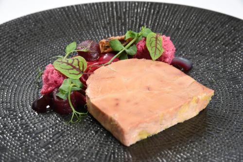 a plate of food with a piece of cheese and grapes at Boutique Hotel Slenaker Vallei - Buitengewoongenieten in Slenaken