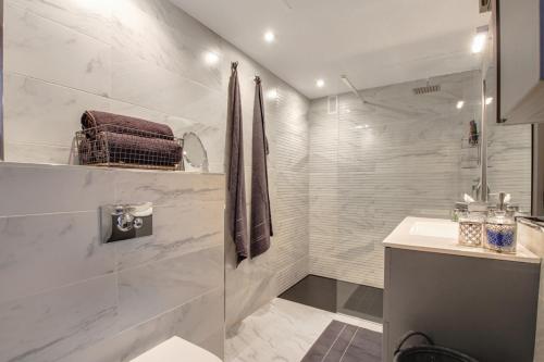 a white bathroom with a shower and a sink at La Nogalera Deluxe Apartment Torremolinos in Torremolinos