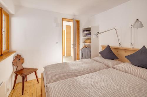 a bedroom with a bed and a table and a chair at DAS HAUS IM WALD in Seefeld in Tirol