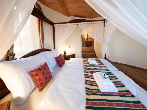 1 dormitorio con 1 cama blanca grande y toallas. en Residence Safari Resort - Chateau, en Borovany