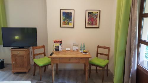 a dining room with a table with chairs and a television at Hotel Goldflair am Rathaus in Korbach