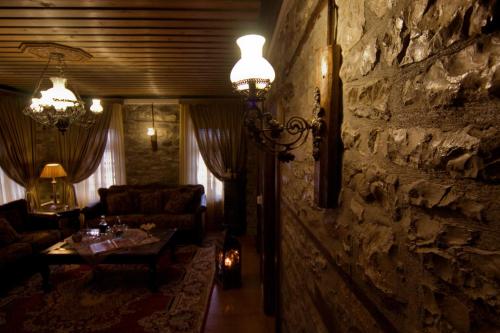 a living room with a stone wall and a table at Archontiko Geki 1876 in Papigko