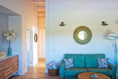 ein Wohnzimmer mit einem grünen Sofa und einem Spiegel in der Unterkunft A Casa da Pereira in Ribadumia