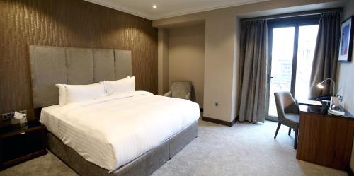 a hotel room with a large bed and a window at Ten Square Hotel in Belfast