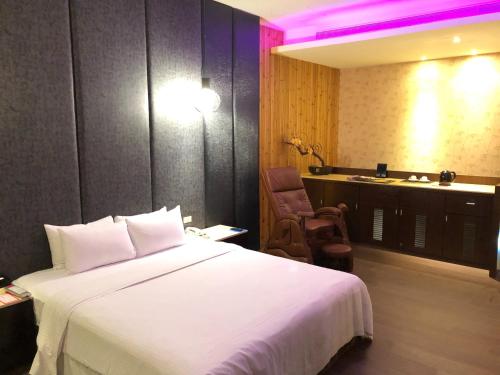 a hotel room with a white bed and a desk at Idee SPA Motel in Yangmei