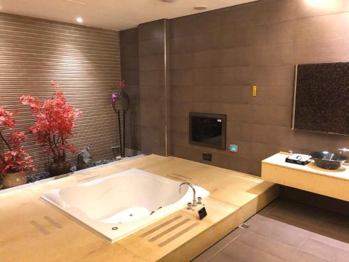 a large bath tub in a bathroom with a tv at Idee SPA Motel in Yangmei
