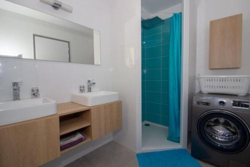 a bathroom with a sink and a washing machine at Villa neuve architecte vue mer in Belvédère