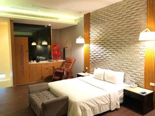 a bedroom with a bed and a chair and a mirror at Idee SPA Motel in Yangmei