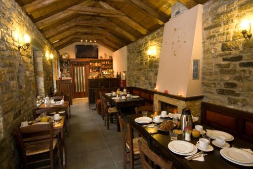 a restaurant with tables and chairs in a room at Archontiko Geki 1876 in Papingo