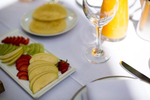 a table with a plate of fruit and a glass of wine at Hôtel particulier Le DOGE - Relais & Châteaux in Casablanca