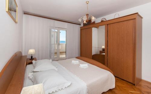 um quarto com uma grande cama branca e uma janela em Apartment Ines em Omiš