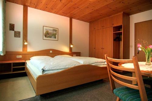 GrafenwiesenにあるGästehaus Fidelisのベッドルーム1室(ベッド1台、デスク、テーブル付)