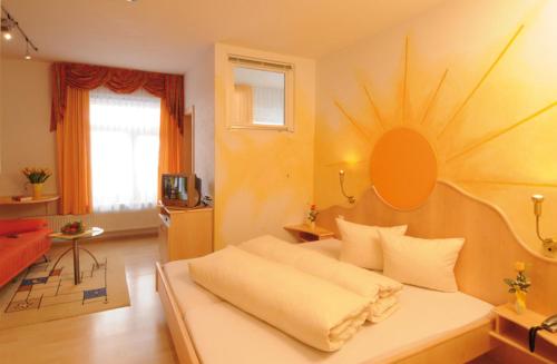 a room with a bed with a sun on the wall at Hotel Camona & Apart Walserhof in Samnaun