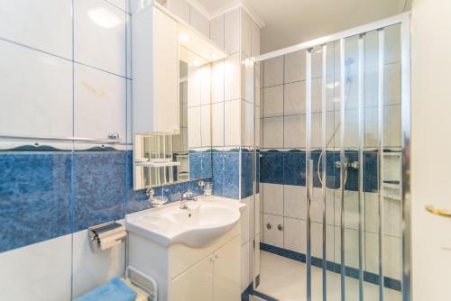 y baño con lavabo y ducha acristalada. en Apartments Canaria, en Pula